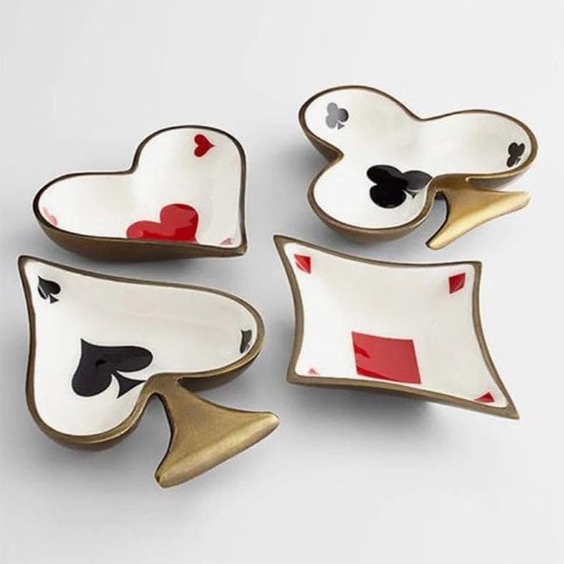 Four small ceramic dishes shaped as the card suits, rimmed in antique gold