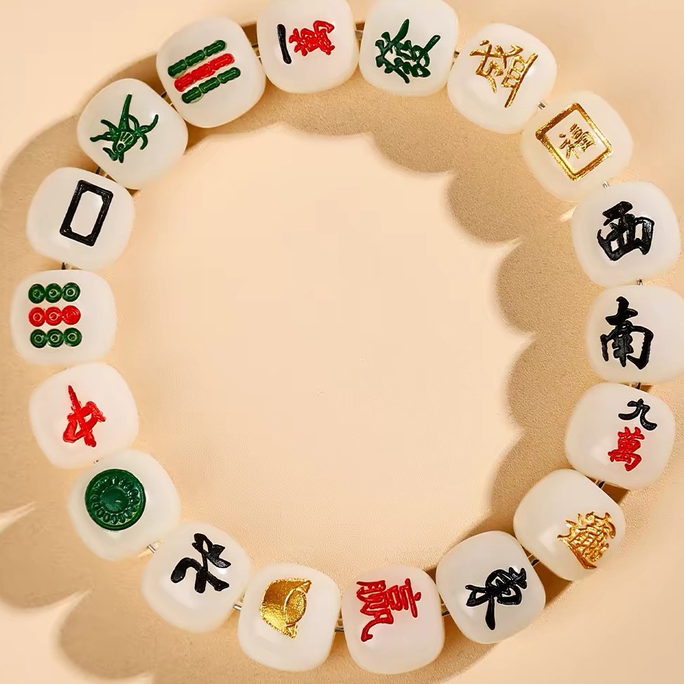 A bracelet of white jade bodhi beads, each carved as a mahjong tile